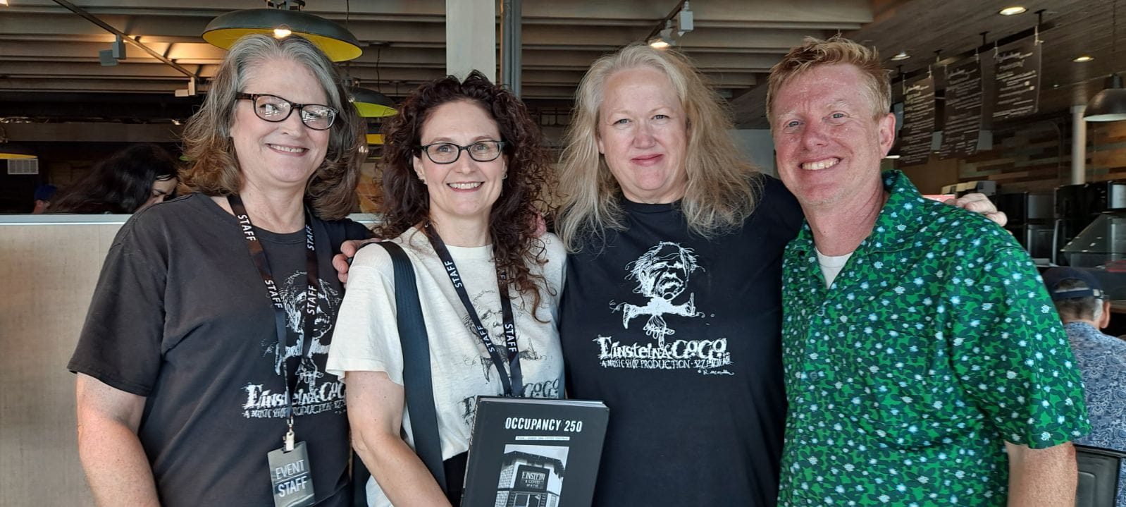 Four happy friends holding a book they just published.